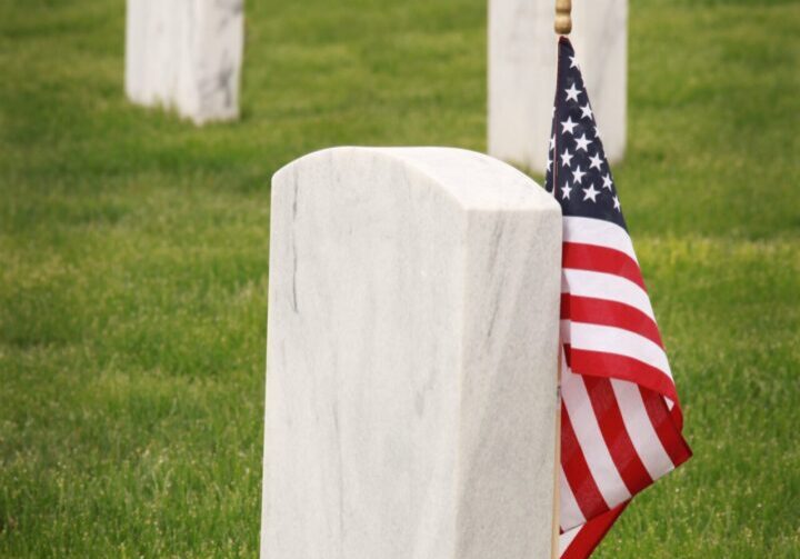 A flag is on top of the grave marker.